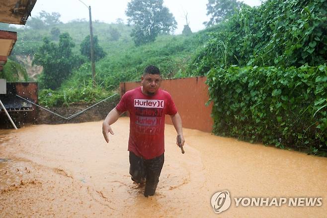 무릎까지 차오른 흙탕물 (카예이 AP=연합뉴스) 18일(현지시간) 푸에르토리코 산악 지대인 카예이 한 가정집이 허리케인 '피오나' 영향으로 침수돼 있다. 2022.9.19 photo@yna.co.kr