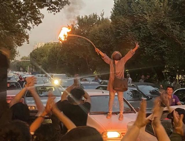 지난 19일(현지시간) 이란 수도 테헤란에서 히잡 강제 착용에 항의하는 한 여성이 히잡을 불태우고 있다. 마시 알리네자드 트위터
