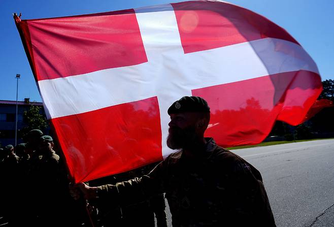 한 덴마크 군인이 덴마크 국기를 들고 있는 모습./로이터 연합뉴스