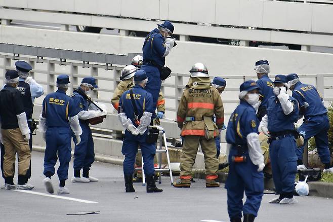 21일 오전 일본 도쿄 총리관저 인근 도로에서 분신을 시도한 것으로 보이는 남성이 발견돼 병원에 후송된 가운데 경찰, 소방관 등이 사건 현장을 조사하고 있다. 사건 현장에서는 아베 신조 전 총리의 국장을 반대한다고 쓰인 문서가 발견됐다.  AP 교도