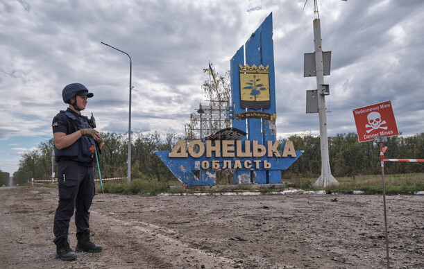 우크라이나군 장병이 20일 동부 하르키우 전선에서 ‘도네츠크주’라고 쓴 입간판 앞에 서 있다. EPA 연합뉴스