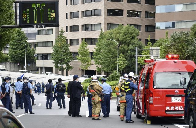 ] 21일 일본 도쿄의 총리 관저 주변 도로에서 한 남성이 분신해 경찰과 소방관들이 현장을 조사하고 있다. AP=뉴시스