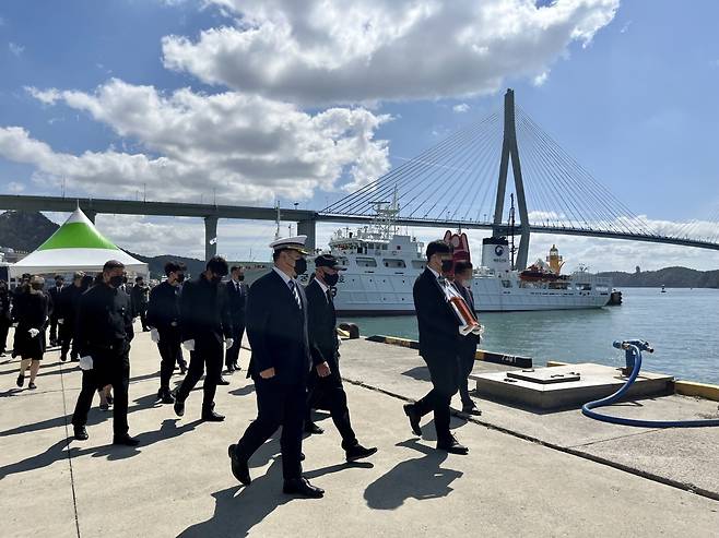 Family members take a final look around Mugunghwa No. 10, the fisheries patrol vessel where Lee last served. Lee’s son holds his father’s portrait in his hands. (Kim Arin/The Korea Herald)