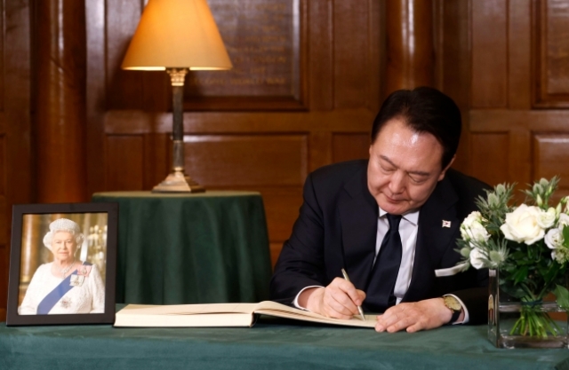 윤석열 대통령이 19일 영국 엘리자베스 2세 여왕 장례식에 참석한 뒤 조문록을 작성하고 있다. 연합뉴스