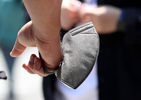 (서울=뉴스1) 박지혜 기자 = 마스크 야외 착용 의무가 해제된 첫날인 2일 서울 종로구 청계천 일대에서 한 시민이 마스크를 손에 든 채 이동하고 있다. 2022.5.2/뉴스1