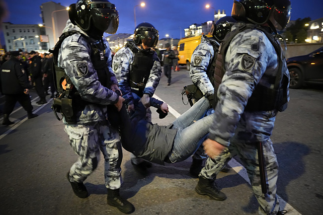 21일(현지시간) 블라디미르 푸틴 러시아 대통령의 군 동원령에 반발해 시위를 벌인 시민을 경찰이 진압하고 있다. AP ·연합뉴스