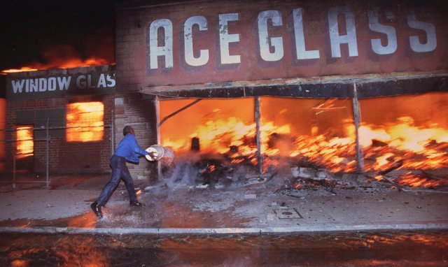 ▲LA폭동. 강 기자가 퓰리처상을 받게 된 사건이다. Cornelius Pettus, owner of Payless market, throws a bucket of water on the flames at neighboring business Ace Glass in Los Angeles, California on April 29, 1992 during the first night of the 1992 Los Angeles Riots. Photo ⓒ Hyungwon Kang/Los Angeles Times