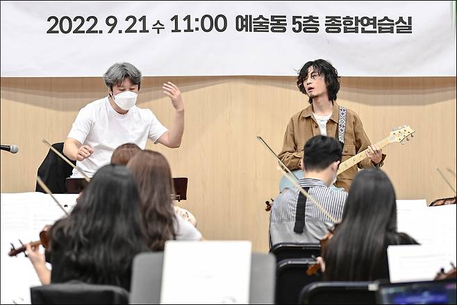 ‘충돌과 조화’를 기획하고 지휘를 맡은 김성국(왼쪽 뒤) 서울시국악관현악단장과 기타리스트 황린(오른쪽 뒤)이 21일 ‘능게’를 연습하고 있다.세종문화회관 제공