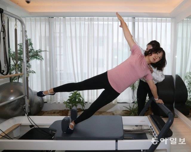 최지윤 한양대병원 외과 교수는 여러 운동에 도전한 끝에 5년 전 필라테스를 시작했고, 이후 거북목과 어깨 뭉침, 허리 통증을 잡는
 데 성공했다. 최 교수가 전문 강사의 도움을 받아 필라테스 기구로 운동하고 있다. 김동주 기자 zoo@donga.com