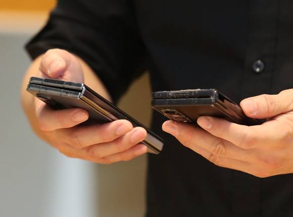 한 시민이 지난 8월11일 서울 서초구 삼성 딜라이트샵에서 '갤럭시Z플립4'를 자신의 휴대폰과 비교하고 있다. /사진=뉴스1