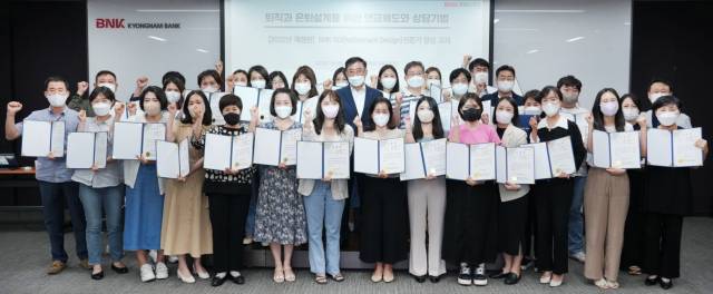 ▲BNK경남은행 은퇴금융 전문 과정을 수료한 은퇴디자인 전문가들이 수료증을 들고 단체 기념촬영을 하고 있다. ⓒBNK경남은행