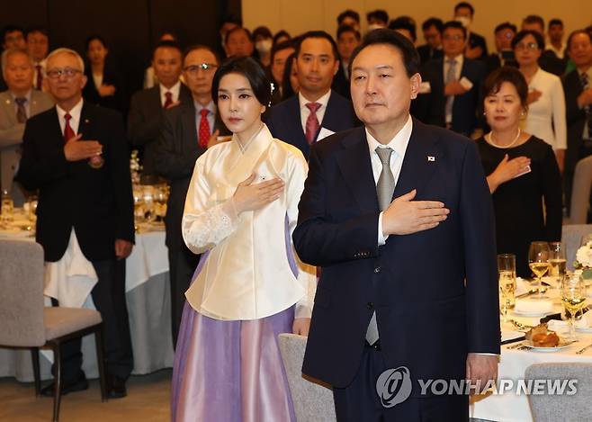 국기에 경례하는 윤석열 대통령 (토론토=연합뉴스) 서명곤 기자 = 윤석열 대통령과 김건희 여사가 22일(현지시간) 캐나다 토론토 한 호텔에서 열린 동포 만찬간담회에서 국기에 경례를 하고 있다. 2022.9.23 seephoto@yna.co.kr