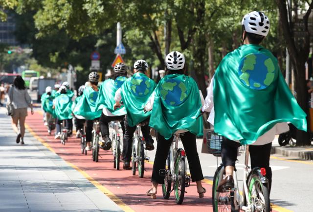 2019년 9월 18일 서울 중구 청계천 광통교에서 '9·21 기후위기 비상행동' 참가자들이 행사를 알리는 캠페인을 위해 자전거도로를 달리고 있다. 연합뉴스