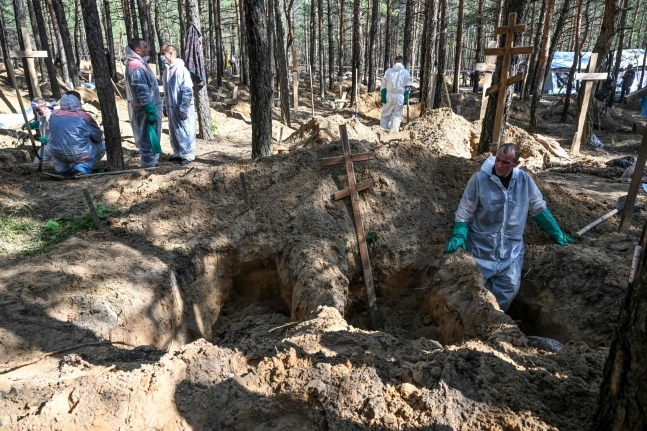 우크라이나 동북부 하르키우주 이지움 외곽 숲속의 집단매장지에서 법의학 조사관들이 조사를 벌이고 있다. / 사진=AFP 연합뉴스