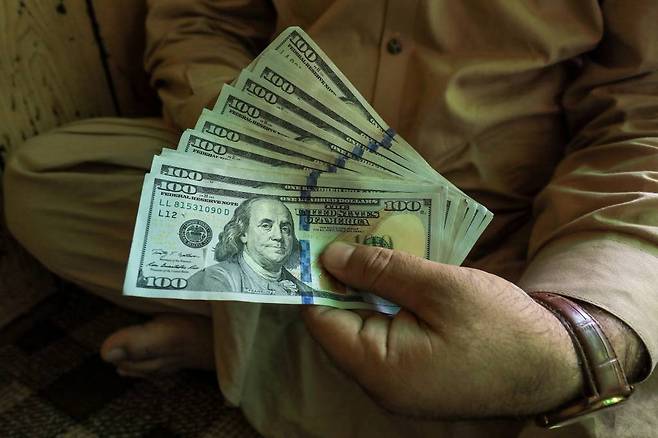 A trader displays U.S. dollar banknotes at a currency exchange booth in Peshawar, Pakistan September 15, 2021. REUTERS/Fayaz Aziz/File Photo/사진=로이터=뉴스1