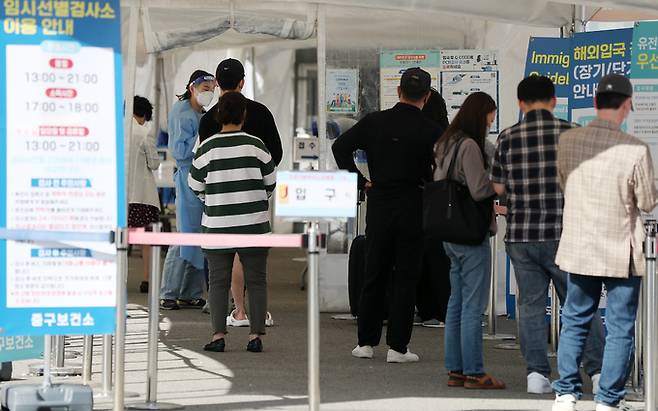 25일 오후 서울역 광장에 마련된 신종 코로나바이러스 감염증(코로나19) 선별검사소를 찾은 시민들이 줄을 서 차례를 기다리고 있다. 뉴스1