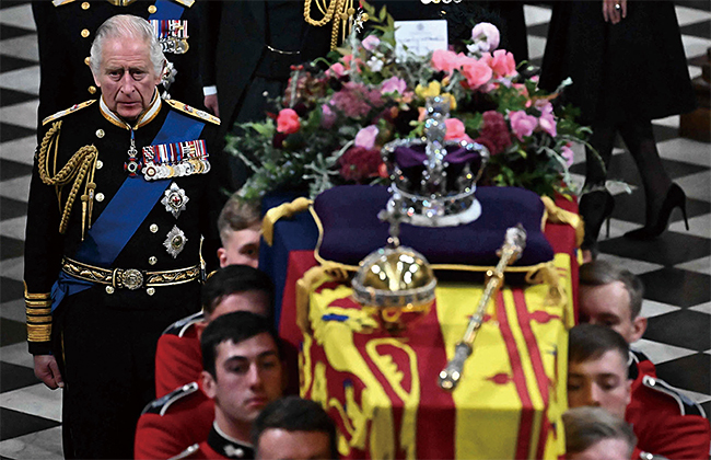 왕관과 보주(寶珠)를 올린 엘리자베스 2세의 관이 찰스 3세 등의 배웅을 받으며 장례식이 열린 웨스트민스터 사원을 나서고 있다. 사진 AFP연합