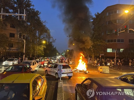 이란 '히잡 미착용 여성 의문사' 항의 시위 격화 (테헤란 AP=연합뉴스) 19일(현지시간) 이란 수도 테헤란 시내에서 '히잡 미착용 20대 여성 의문사 사건'에 항의하는 시위가 벌어진 가운데 경찰 오토바이가 불타고 있다. 2022.9.21 leekm@yna.co.kr (끝)