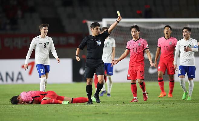 26일 경기도 화성종합경기타운 주 경기장에서 열린 올림픽 축구 대표팀 평가전 한국과 우즈베키스탄의 경기에서 오현규가 파울을 당한 뒤 고통스러워하는 동안 주심이 우즈베키스탄 다브르노프에게 경고를 주고 있다. 김혜윤 기자