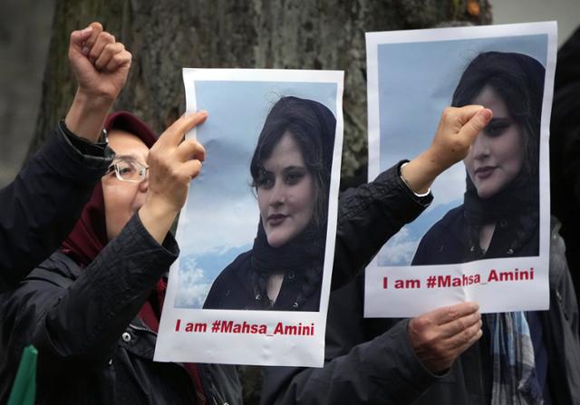 20일(현지시간) 독일 베를린 이란 대사관 앞에서 서방에서 활동하는 이란 반정부단체 '이란국민저항위원회'(NCRI)의 망명 이란인들이 이란에서 최근 히잡을 쓰지 않았다는 이유로 경찰에 체포된 22세 여성 마흐사 아미니가 의문사한 사건에 대한 진상조사 등을 촉구하며 시위를 벌이고 있다. 베를린=AP 연합뉴스