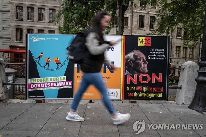 23일(현지시간) 제네바에서 여성의 정년연장 반대 포스터를 지나치는 시민 [AFP 연합뉴스 자료사진. 재판매 및 DB 금지]