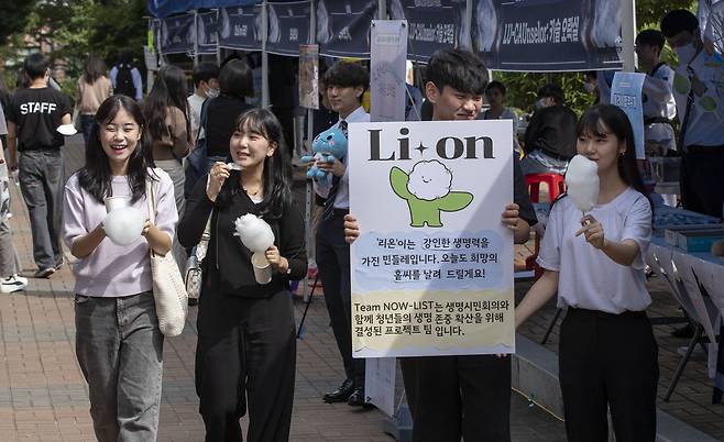 실외 마스크 착용 의무가 해제된 26일 서울 동작구 흑석동 중앙대학교에서 열린 가을축제에서 학생들이 솜사탕을 먹으며 활짝 웃고 있다. /박상훈 기자
