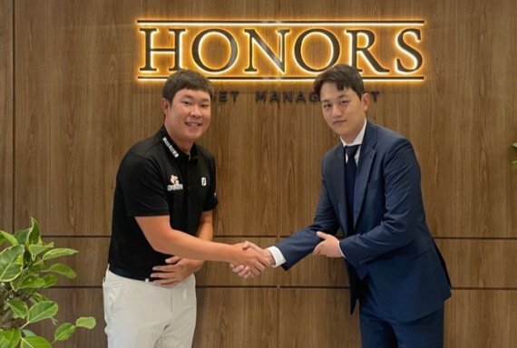 목진오 아너스자산운용 대표이사가 후원계약을 체결한 김민준 KPGA 골프선수(왼쪽)와 악수를 나누며 기념사진을 찍고 있다. 아너스자산운용 제공