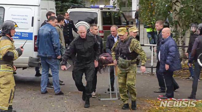 [이젭스크=AP/뉴시스] 26일(현지시간) 러시아 우드무르티야공화국 이젭스크에 있는 88번 학교에서 총격이 발생해 군인들이 부상자를 옮기고 있다. 경찰은 무장 괴한이 이 학교에서 총기를 난사해 어린이 11명 등 15명이 숨지고 24명이 다쳤다고 밝혔다. 2022.09.27.