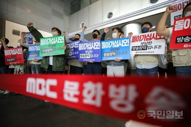 전국언론노동조합 MBC본부 조합원들이 28일 서울 마포구 MBC본사 로비에서 MBC를 항의 방문한 국민의힘 의원들을 향해 구호를 외치고 있다.