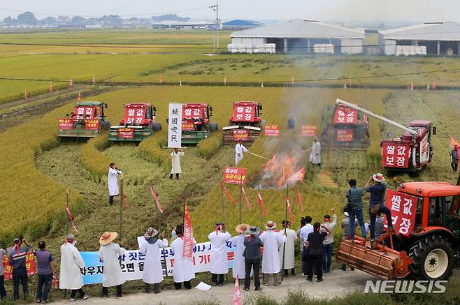 [정읍=뉴시스] 김종효 기자 = 28일 전북 정읍시이평면 만석보 들녁에서 정읍농민회가 주관하는 '쌀값보장 농민생존권 쟁취를 위한 논 갈아엎기 집회'가 열렸다. 쌀값보장을 요구하는 농민들이 정부에 항의하는 뜻으로 수확 전 벼를 불태우며 논까지 갈아 엎고 있다. 2022.09.28. kjh6685@newsis.com