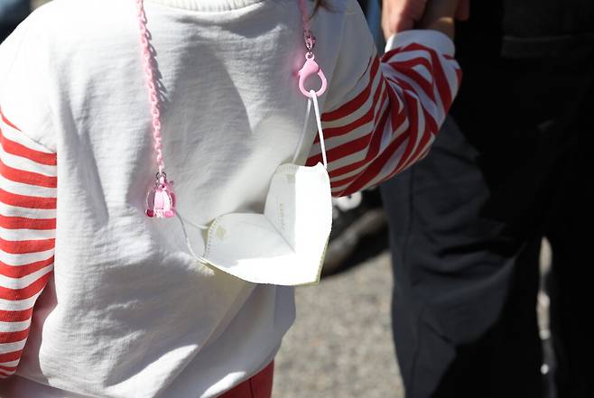 실외 마스크 착용의무 전면 해제를 하루 앞둔 25일 오후 서울시내 거리축제에 참가한 한 어린이가 마스크를 목에 걸고 있다. 연합뉴스