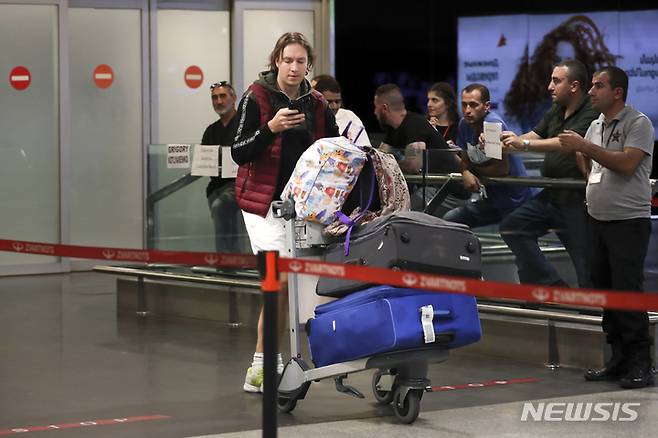 [예레반=AP/뉴시스] 22일(현지시간) 아르메니아 예레반 외곽의 국제 공항에 도착한 러시아 남성이 짐을 끌고 이동하고 있다. 블라디미르 푸틴 러시아 대통령이 예비군 부분 동원령을 내린 지 하루 만에 많은 러시아 남성이 러시아를 떠나는 것으로 알려졌다. 2022.09.23.