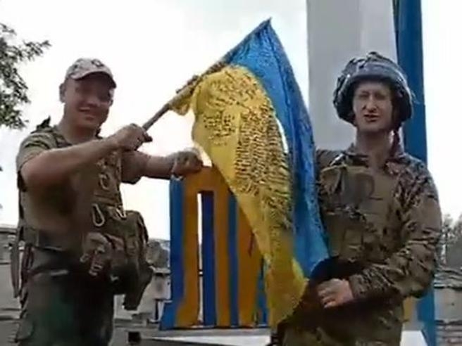 리만 도시 표지판에 국기 꽂는 우크라이나 군인들  [우크라이나 대통령 비서실 제공 동영상 캡처. 재판매 및 DB 금지]