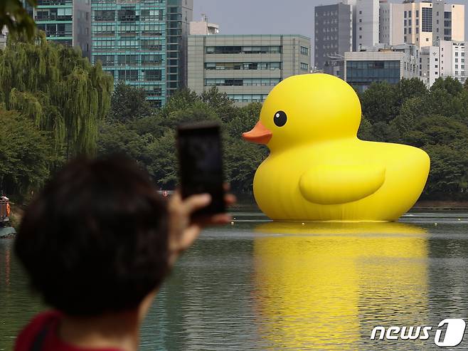 2일 오후 서울 송파구 석촌호수에서 시민들이 대형 고무 오리 '러버 덕(Rubber Duck)'을 사진 찍고 있다. 러버덕은 네덜란드 출신 ‘플로렌타인 호프만’ 작가의 대형 공공미술 프로젝트로, 현재까지 16년간 전 세계 16개국을 순회하며 25회 이상의 전시를 이어가고 있다. 이번 ‘러버덕 프로젝트 서울 2022’는 코로나로 지쳐있는 우리 모두에게 힐링과 기쁨, 희망의 메시지를 전달하기 위해 기획됐고 다음달 31일까지 총 32일 동안 진행된다. 2022.10.2/뉴스1 ⓒ News1 신웅수 기자