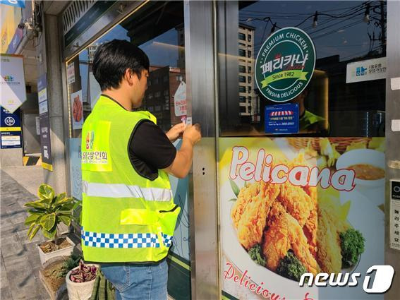 점자문패를 부착하는 이희문 상인회장