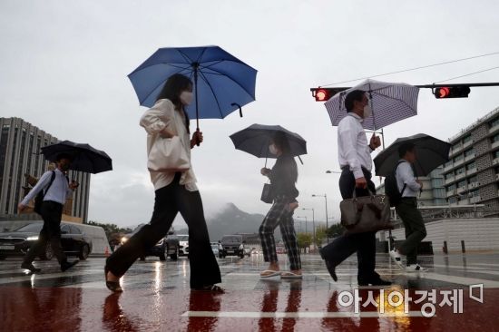 중부지방을 중심으로 비가 내린 30일 서울 광화문 사거리에서 출근길 시민들이 발걸음을 재촉하고 있다. /문호남 기자 munonam@