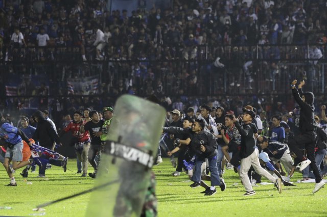 1일(현지시간) 인도네시아 동부 자바 말랑의 칸주루한 경기장에서 축구 팬들이 경기장에 난입하고 있다. AP 뉴시스