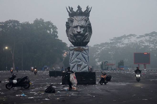 오토바이를 탄 시민들이 2일 전날 관중들의 경기장 난입으로 최소 129명이 숨지는 사고가 발생한 인도네시아 자바의 칸주르한 경기장 앞을 지나가고 있다. 자바/AP 연합뉴스