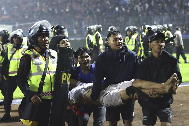 1일(현지시각) 인도네시아 자바 축구경기장에서 발생한 폭동으로 최소 127명이 사망했다. 폭동이 발생한 칸주루한 경기장에서 축구팬들이 부상자를 옮기고 있다 / AP=연합뉴스