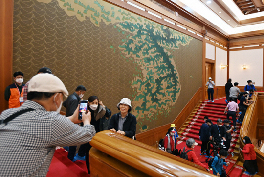 청와대가 일반에 공개된 후인 지난 5월 26일 청와대 본관을 찾은 관람객들이 대형 벽화 ‘금수강산도’를 배경으로 기념 사진을 찍고 있다. 윤성호 기자