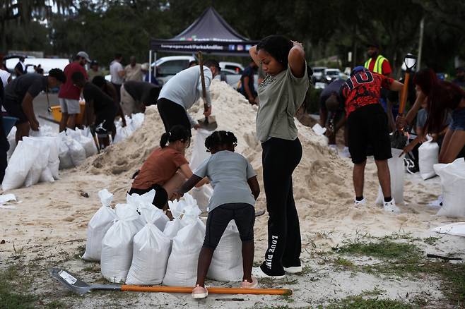 26일(이하 현지시간) 미국 플로리다주 탬파의 한 공원에서 시민들이 허리케인 '이안'(Ian)에 대비해 모래주머니에 모래를 채우고 있다. 강풍과 폭우를 동반한 허리케인 '이안'은 현재 쿠바 근해에 있으며 오는 29일 오후께 플로리다에 상륙할 전망이다. [연합]