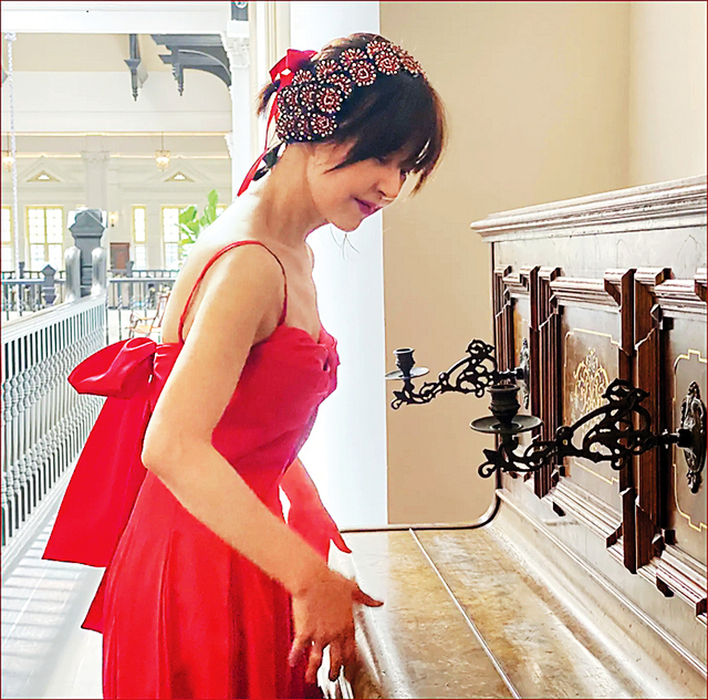 방송인 서정희씨가 지난 8월 싱가포르 호텔의 피아노 앞에서 빨간 드레스를 입고 포즈를 취하고 있다.