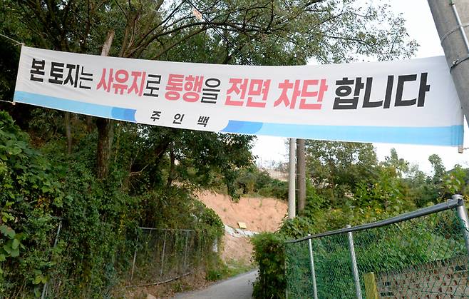 [광주=뉴시스] 김혜인 기자 = 30일 오후 광주 남구 봉선동과 동구 용산동을 잇는 통행로 입구에 '사유지 통행 금지' 현수막이 붙어있다. 땅 주인이 땅 소유권을 주장하며 통행을 차단한 상태다.2022.09.30.hyein0342@newsis.com