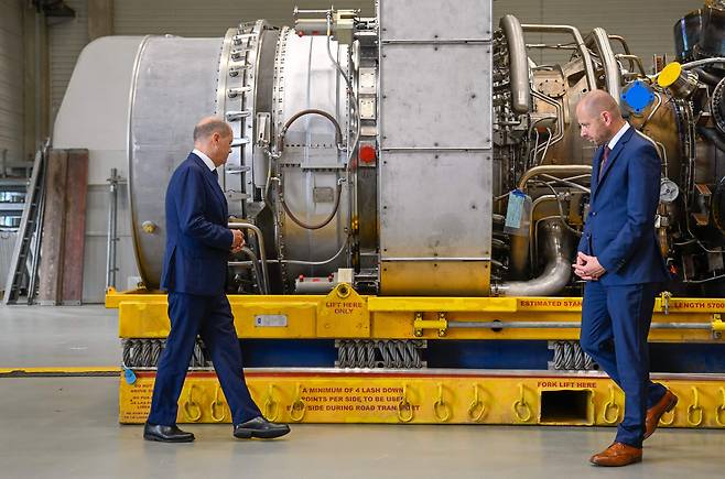 올라프 숄츠(왼쪽) 독일 총리가 지난달 3일(현지 시각) 독일 서부 뮐하임안데어루르에 있는 지멘스 에너지 공장에 캐나다에서 수리를 마친 뒤 보관되고 있는 노르트스트림1 가스관 터빈을 살펴보고 있다.