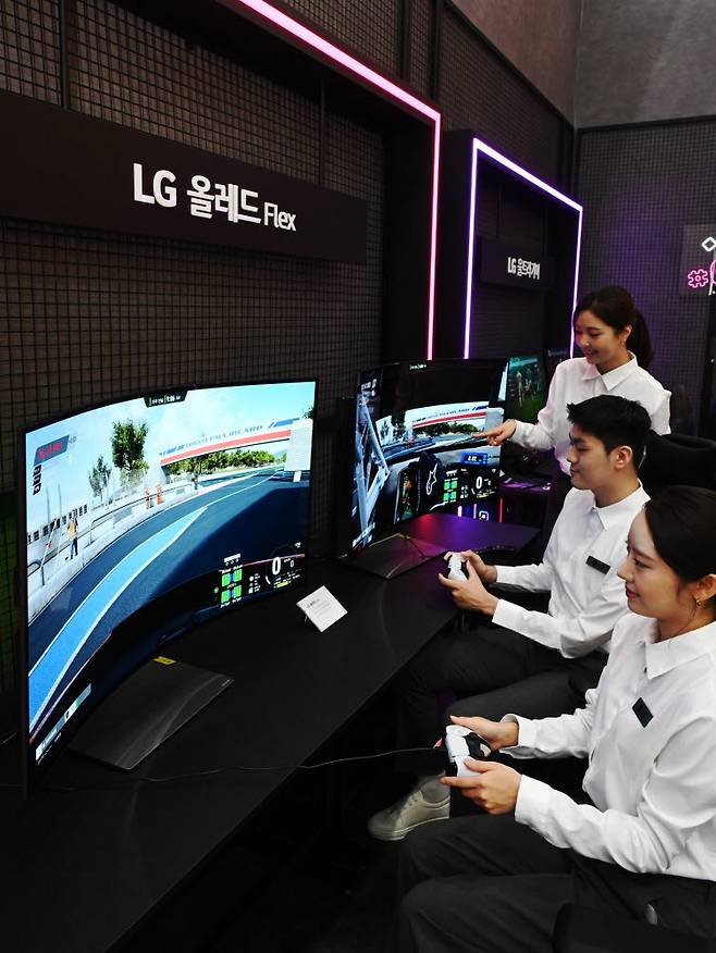 LG전자 모델들이 4일부터 나흘간 서울 삼성동 코엑스에서 열리는 한국전자전(KES 2022)에서 벤더블 게이밍 올레드 TV 플렉스(FLEX)로 게임을 즐기고 있다.