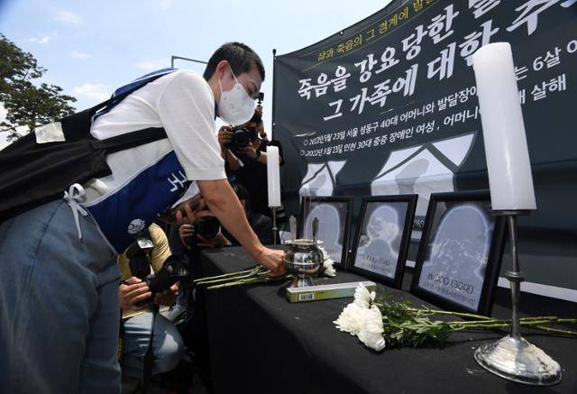 전국장애인부모연대 회원들이 올해 5월 서울 용산구 전쟁기념관 6·25 상징탑 앞에서 죽음을 강요당한 발달장애인과 그 가족에 대한 추모제를 진행하는 중 한 참가자가 임시분향소에 헌화하고 있다. 홍인기 기자