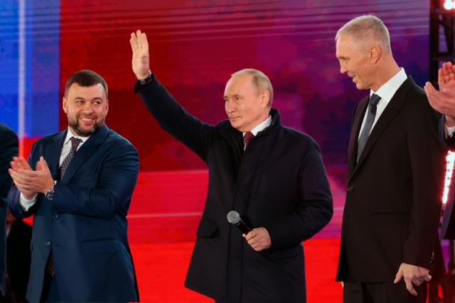 블라디미르 푸틴(가운데) 러시아 대통령이 지난달 30일 모스크바 붉은광장에서 열린 우크라이나 점령지 병합 기념행사에 참석해 군중을 향해 손을 흔들며 인사하고 있다. 모스크바=AP 뉴시스