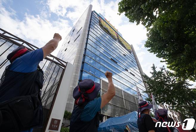 전국민주노동조합총연맹(민주노총) 공공운수노조 화물연대 조합원들이 지난 8월24일 오전 서울 강남구 하이트진로 본사 앞에서 옥상 광고탑 농성중인 동료 조합원들을 향해 손을 들어보이고 있다./사진=뉴스1