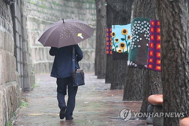 서울 중구 덕수궁 인근에서 한 시민이 우산을 쓴 채 이동하고 있다. [연합뉴스 자료사진]