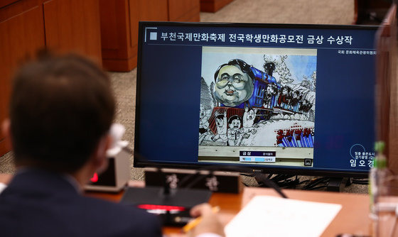 박보균 문화체육관광부 장관이 5일 서울 여의도 국회에서 열린 문화체육관광위원회 국정감사에서 임오경 더불어민주당 의원이 준비한 ‘윤석열차’ 만화 관련 자료화면을 보고 있다. 사진공동취재단 2022.10.5/뉴스1